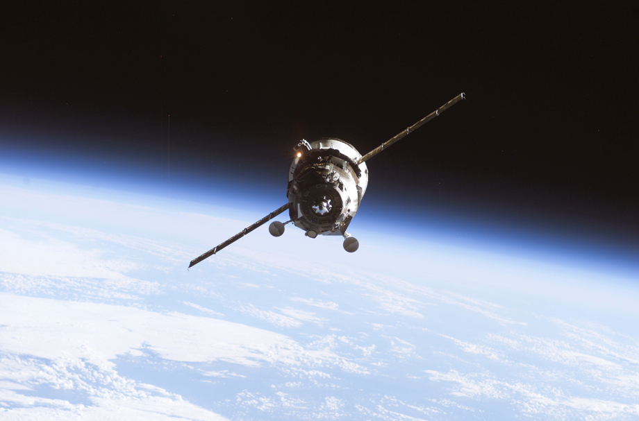 Ein unbemanntes Progress Belieferungsfahrzeug nähert sich der International Space Station mit dem Horizont der Erde als Hintergrund.