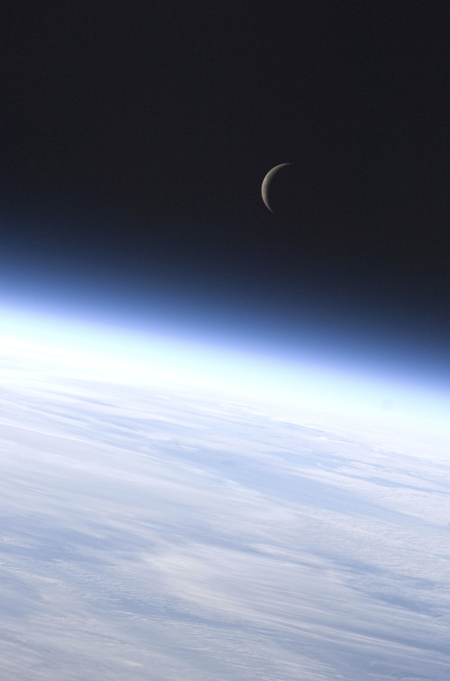 Ein Viertelmond über dem Horizont der Erde.