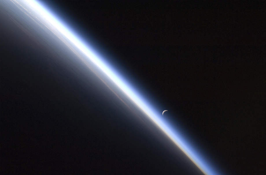 Ein Viertelmond über dem Horizont der Erde.